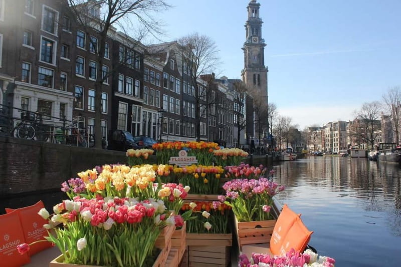 Amsterdam: Premium Tulip Boat Canal Tour - A tulip-filled boat beside Central Station