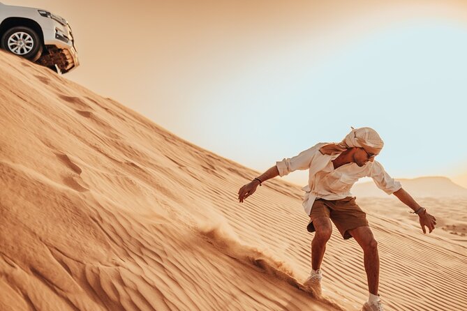 Deluxe Sunset Desert Safari: SandSurfing, Camel Ride & BBQ dinner - Sandboarding at the Golden-Hour Photo Stop
