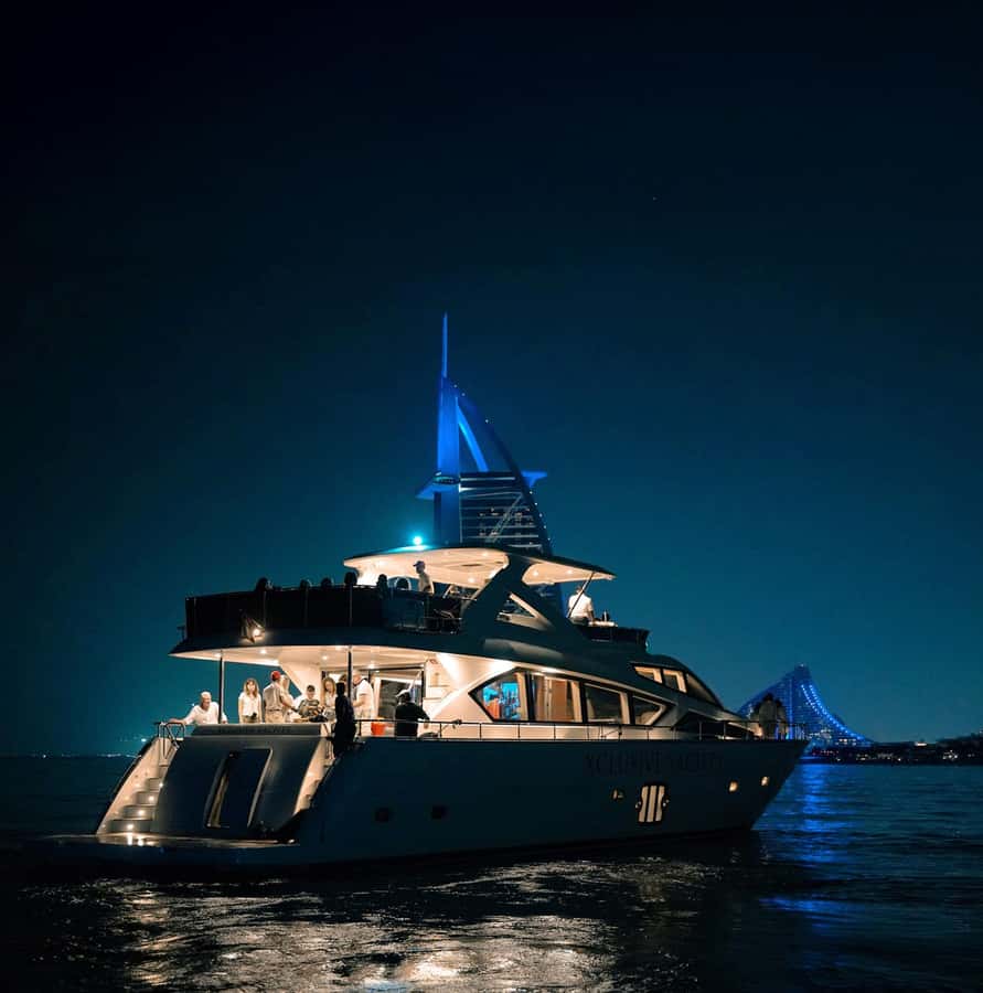 A private motor yacht lit up on the water at night